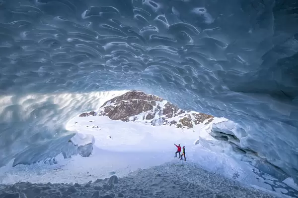 Hikers inside the ice cave in Val Roseg, Pontresina, Canton of GraubAonden, Engadine
