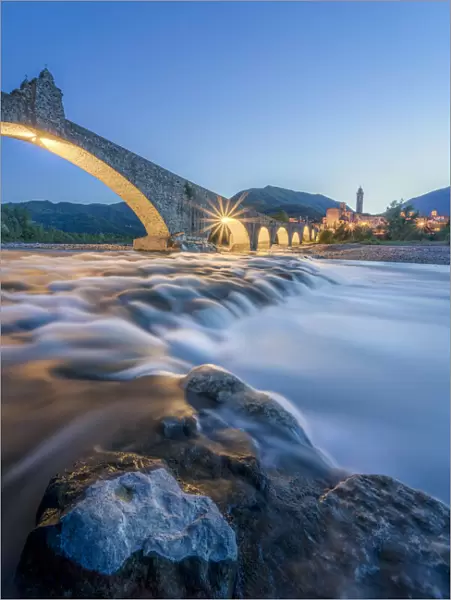 Europe, Italy, Emilia Romagna: Bobbio, falls on the Trebbia river and the medieval town at twilight