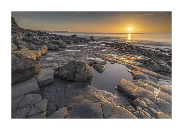 Sunrise over Lyme Bay from the Ammonite Pavement, Lyme Regis, Dorset, England. Winter (February) 2022