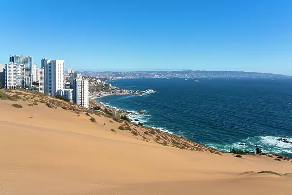 Sand dunes with high-rise buildings on coast and distant view of Vina del Mar and Valparaiso, Concon, Valparaiso Province, Valparaiso Region, Chile