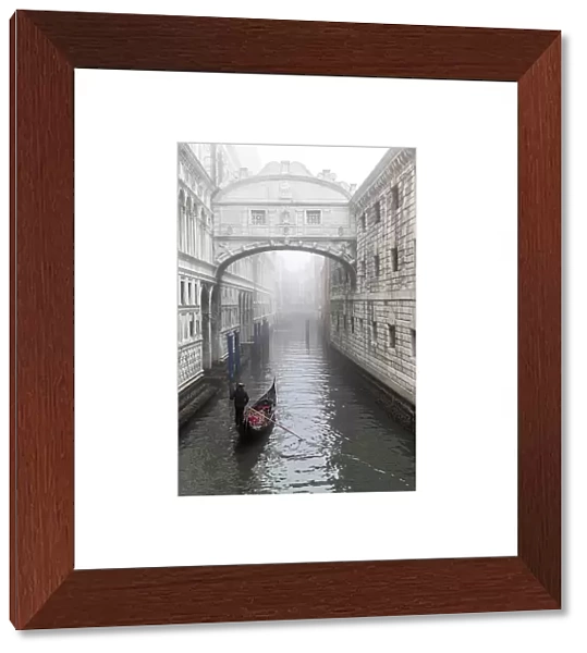 Italy, Veneto, Venice, a gondola moves towards the bridge of Sighs on a foggy day