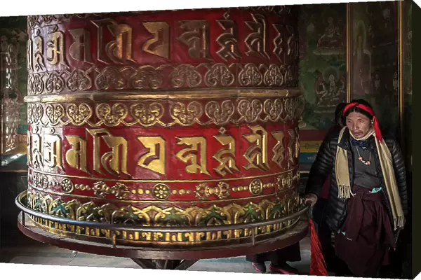 Devotee spinning prayer wheel in temple at Boudhanath Stupa, Kathmandu, Nepal