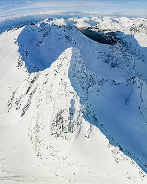 Aerial panoramic view of Litjemoa mountain peak covered with snow, Bergsfjorden, Senja, Troms county, Norway