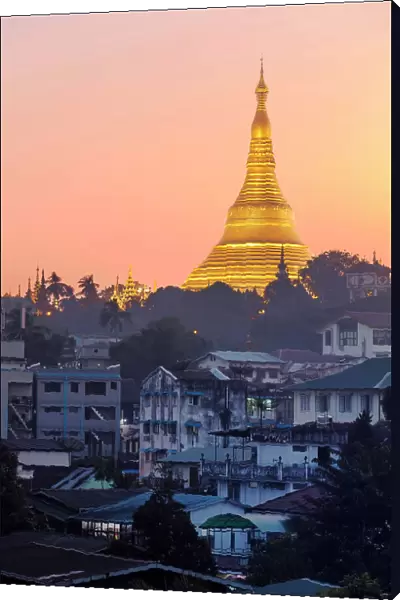The golden stupa of the Shwedagon Pagoda (Shwedagon Zedi Daw) at twilight, Singuttara Hill, Yangon, Myanmar. It is considered the most sacred Buddhist pagoda in the country