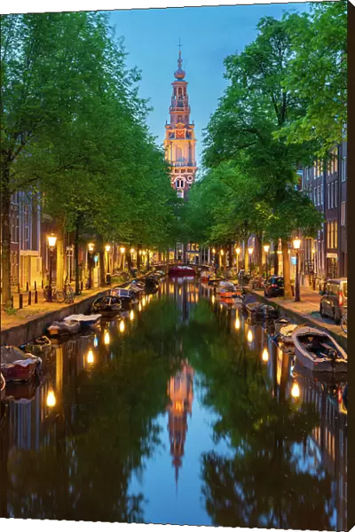 Zuiderkerk Tower near trees and buildings at Groenburgwal canal at twilight, Nieuwmarkt, Amsterdam, Netherlands