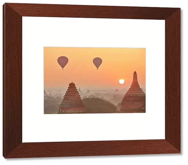 Hot air baloons flying at sunrise over the Bagan Valley archaeological area temples, Old Bagan, Mandalay Region, Myanmar. Bagan was declared a UNESCO World Heritage Site in 2019