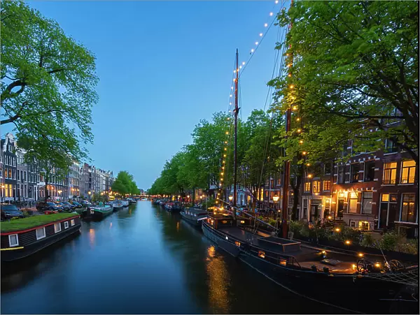 Boats and houses along Brouwersgracht canal at twilight, De Wallen, Amsterdam, Netherlands