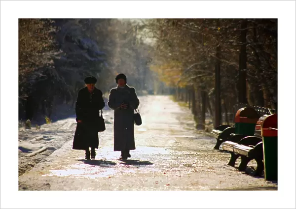 Russia, Far East, Sakhalin; Yuzhno-Sakhalinsk; Two elderly woman walking amidst trees in the main park of