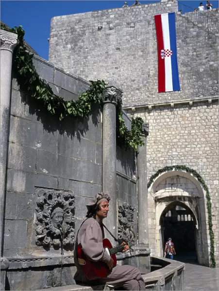 20038512. CROATIA Dalmatia Dubrovnik Onofrio fountain and man in costume playing a guitar