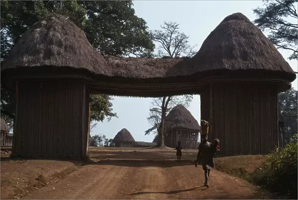 20050549. CAMEROON Bafut Thatched gateway with woman and children below