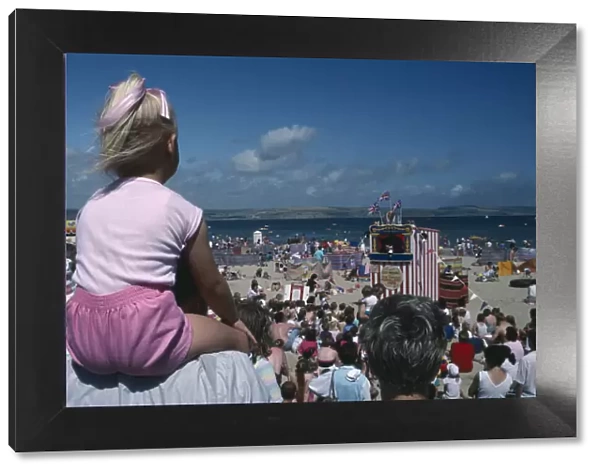 10001559. ENGLAND Dorset Weymouth View over crowds on the beach viewing Punch