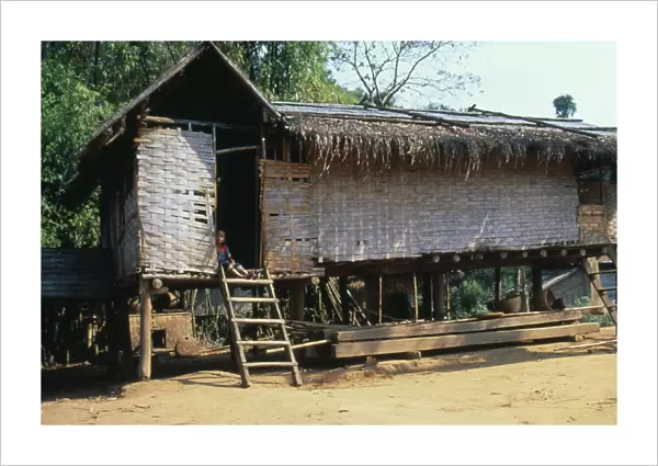 20031567. LAOS Housing Thatched house raised on stilts in small village up river