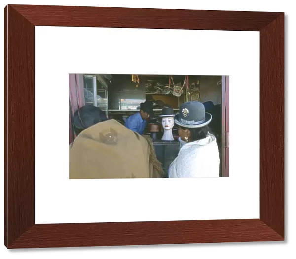 20049584. BOLIVIA La Paz El Alto La Ceja. Two women standing in front of hatmakers stall