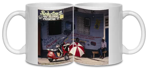 Guyana, Georgetown, Snack vendor in front of building advertising electrical equipment