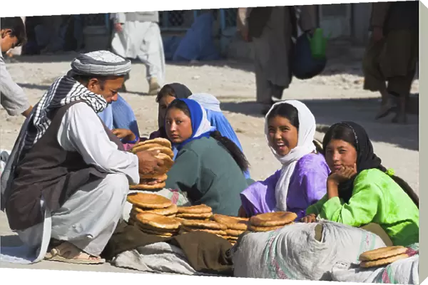 20085103. AFGHANISTAN Mazar-I-Sharif Man buying bread from girls