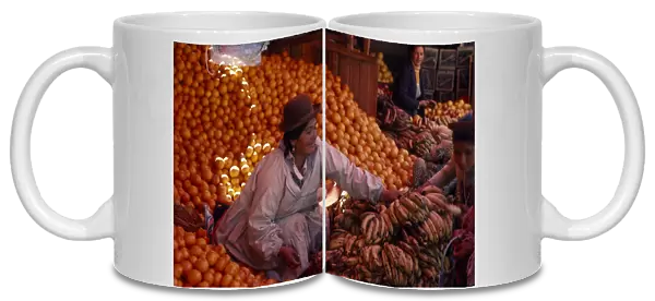BOLIVIA, Potosi Woman selling oranges and bananas from her stall at market