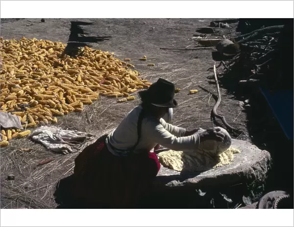 BOLIVIA, Yayani Near Cochabamba. Woman grinding maize