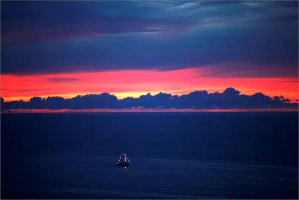 A boat sails during the sunset in the sea of Fortaleza