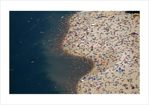 An aerial view shows people at a beach on the shores of the Silbersee lake on a hot