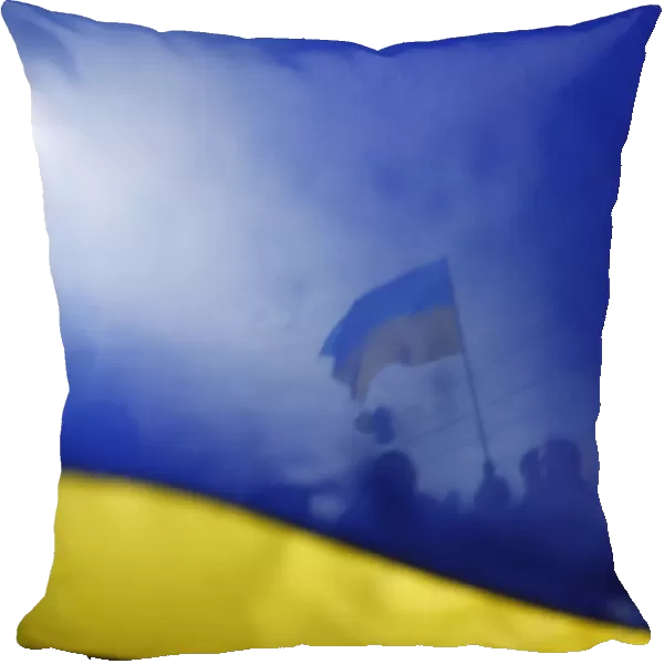 Pro-Ukrainian supporters are seen though a Ukrainian flag as they take part in a rally