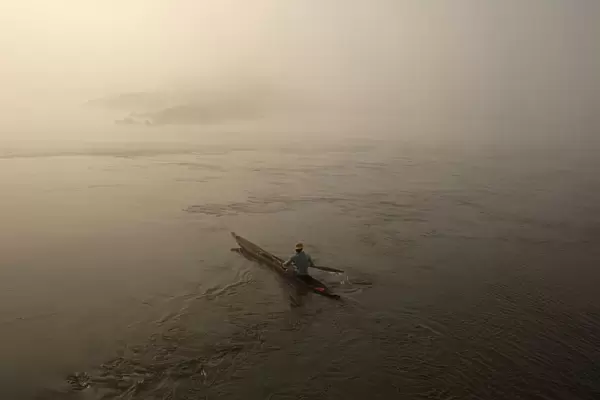 A fisherman paddles his boat on the river Oubangui in Bangui