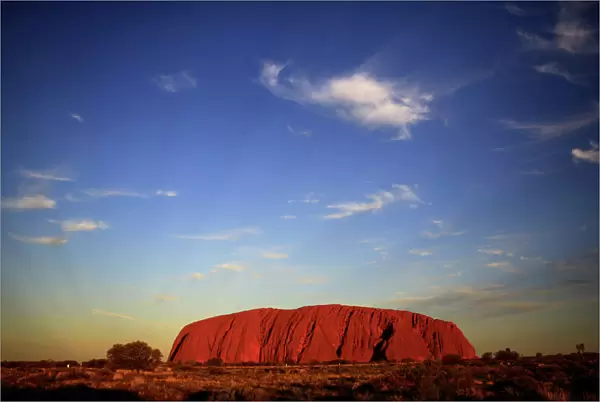 Uluru is lit by the setting sun in the Northern Territory in central Australia