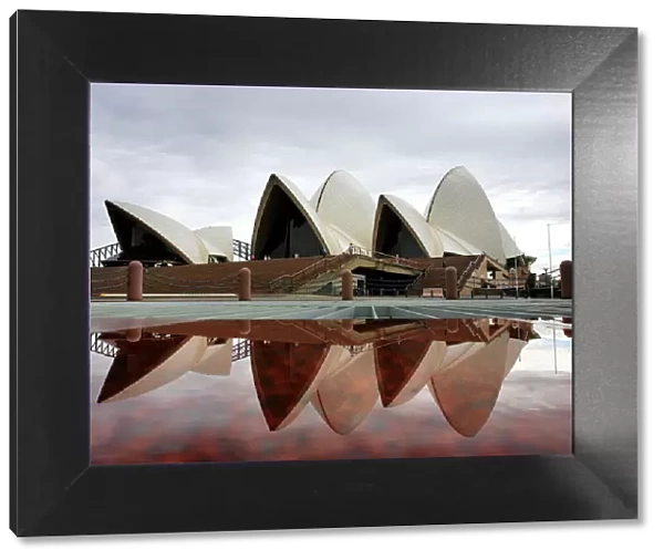 Sydneys landmark Opera House is reflected in a pool of rain water March 31, 2005