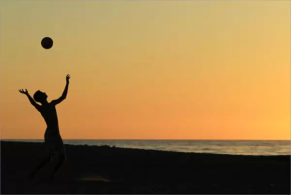 A volleyball player serves at Moonlight Beach in Encinitas, California