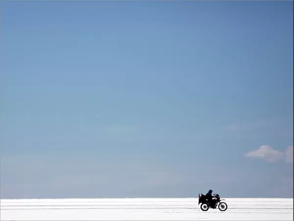 A visitor on a bike rides on the salt flat during the eighth stage of the Dakar Rally