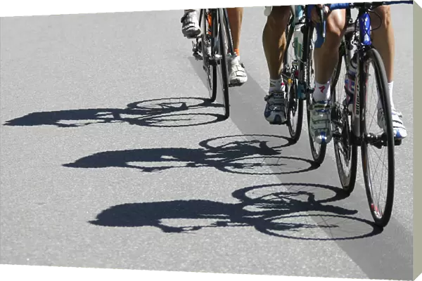 Riders shadows are projected on the road during the fourth stage of the Tour de Suisse