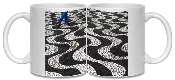 A woman walks over patterned paving in central Porto Alegre during the 2014 World