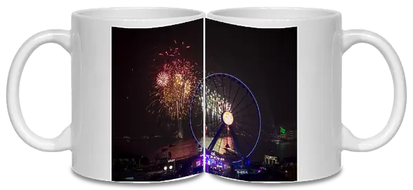 Fireworks explode near the observation wheel during a pyrotechnic show to celebrate