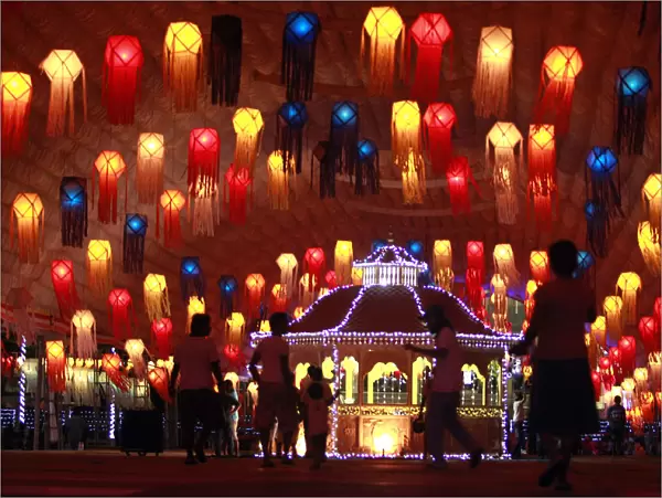 People walk past lanterns on Vesak day in Colombo