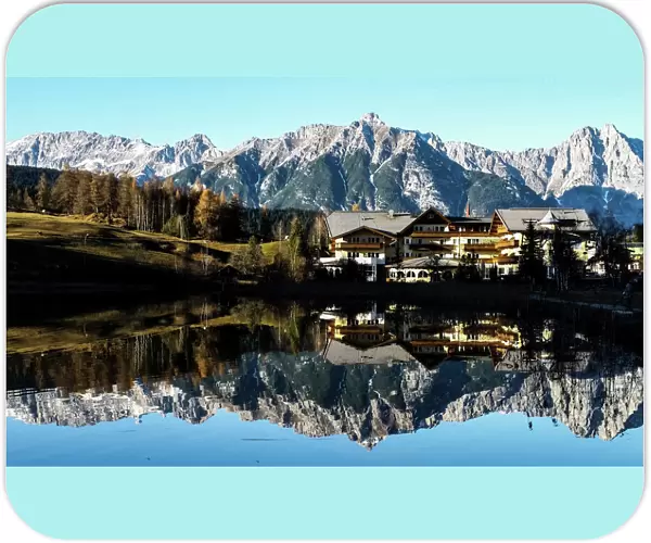Mountains are reflected in a small lake on a sunny autumn day in the western Austrian