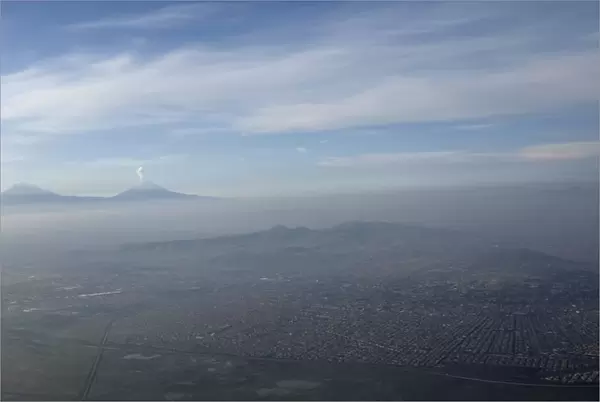 An aerial view of Mexico City is seen, with the Popocatepetl volcano in the background