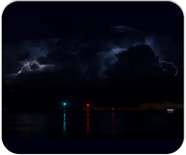A lightning storm is seen beyond the entrance to Vallettas Grand Harbour
