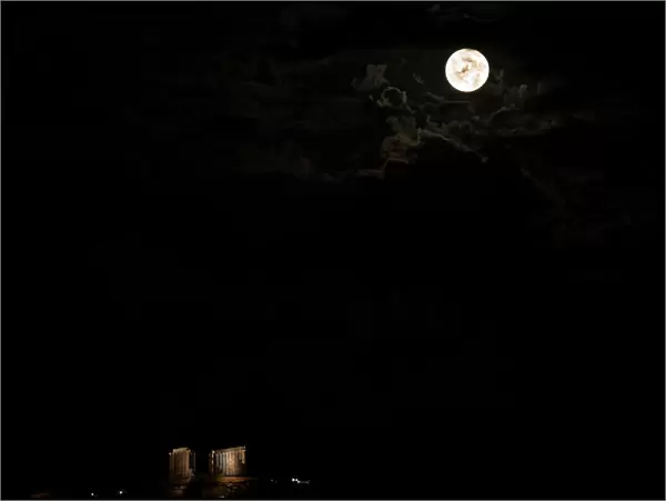 A full moon rises over the Temple of Poseidon in Cape Sounion, near Athens