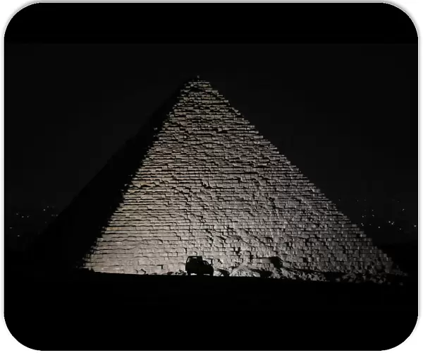 A police car is seen in front of the Great Pyramids in Giza, on the outskirts of Cairo