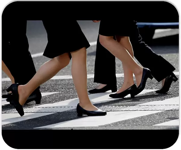 Women in high heels walk at a business district in Tokyo