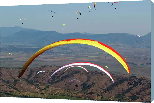 Pilots fly their paragliders during 16th FAI Paragliding World Championship in Krusevo