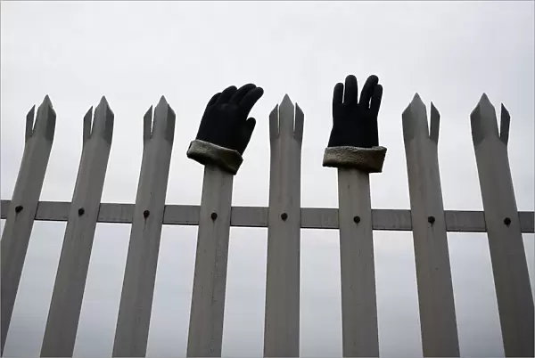 Protective work gloves are seen on railings surrounding the Bombardier plant in Belfast