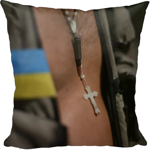 A cross and bullet are seen on Ukrainian serviceman as he stands in his camp near Donetsk