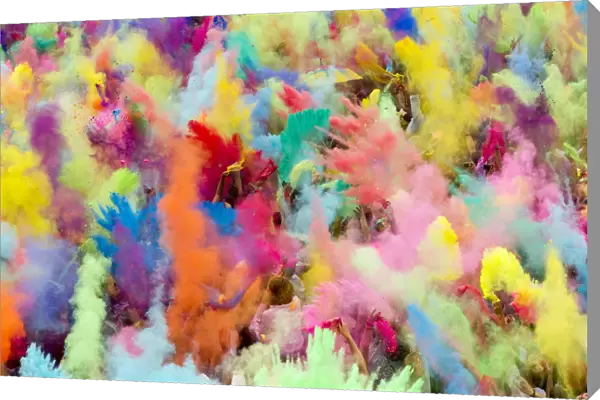 People throw coloured powder in the air during Holi festival celebrations in Berlin