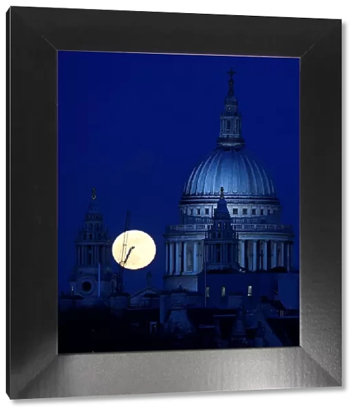 A full moon rises behind St Pauls Cathedral London