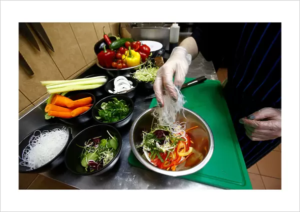 Employee prepares a salad in vegetarian restaurant Green Cuisine in Minsk