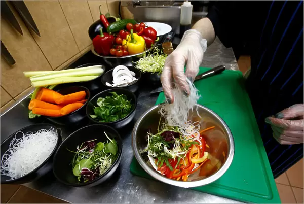Employee prepares a salad in vegetarian restaurant Green Cuisine in Minsk