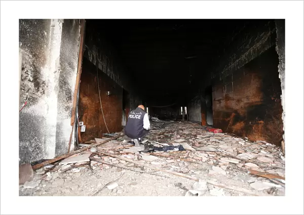 Security personnel inspects the site of a suicide attack on the electoral commission in
