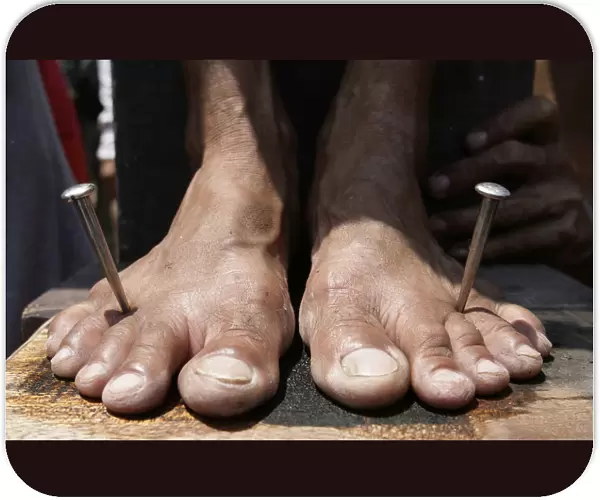 A penitents feet are nailed to a wooden cross on Good Friday in the town of San Juan in