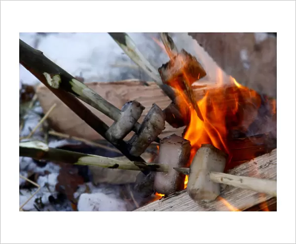 Local residents put pig fat in a camp fire during the celebrations of Kolyada pagan