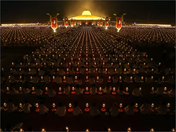 Thousands of believers join Buddhist monks praying at the Wat Phra Dhammakaya temple